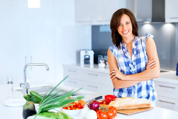 Schöne Frau steht in der Küche und lächelt — Stockfoto