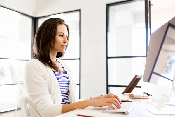 Porträt einer Geschäftsfrau, die im Büro am Computer arbeitet — Stockfoto