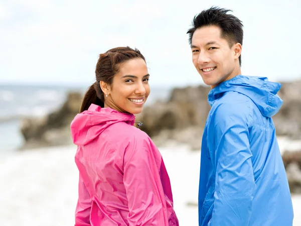 Jeune couple debout à la plage — Photo