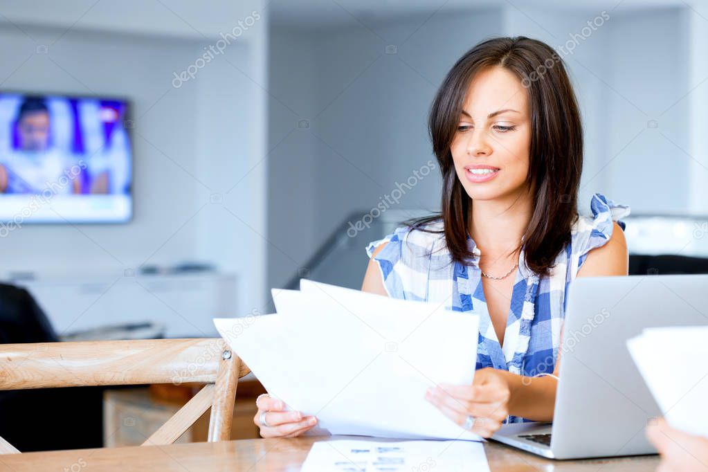 Woman with papers in their living room