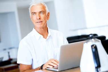 Adam evde dizüstü bilgisayarla çalışıyor.