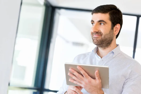 Junger hübscher Geschäftsmann mit Touchpad im Büro — Stockfoto