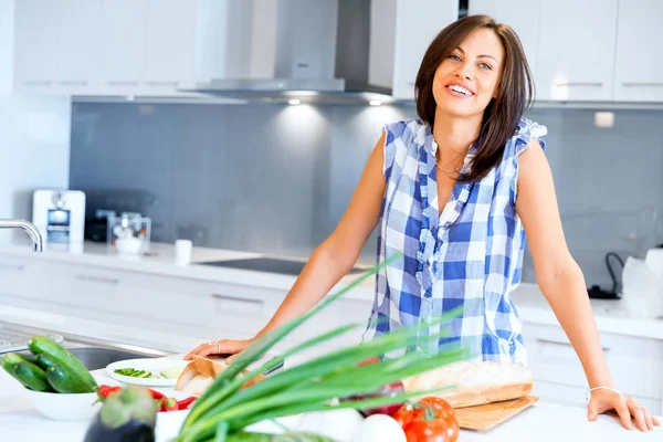 Mulher bonita de pé na cozinha e sorrindo — Fotografia de Stock