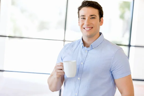 Joven hombre de negocios en la oficina con una taza —  Fotos de Stock