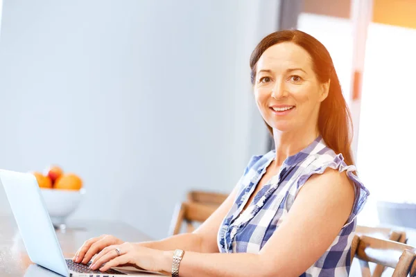 Mulher bonita madura trabalhando em seu laptop — Fotografia de Stock