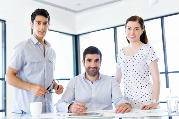 Groep van gelukkige jonge zakenmensen in een vergadering — Stockfoto