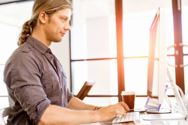 Bilgisayarda çalışan yakışıklı işadamı