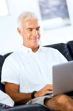 Adam evde dizüstü bilgisayarla çalışıyor.