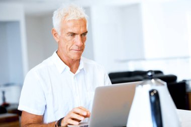 Adam evde dizüstü bilgisayarla çalışıyor.