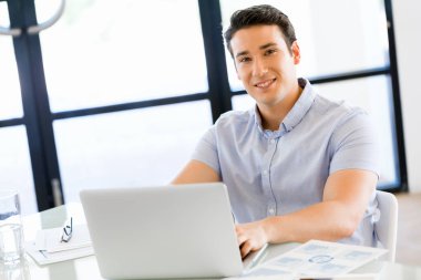 Bilgisayarda çalışan yakışıklı işadamı