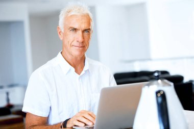 Adam evde dizüstü bilgisayarla çalışıyor.