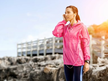 Deniz kıyısında kulaklık sportif kadınla