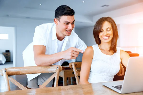 Gelukkige moderne paar bezig met laptop thuis — Stockfoto