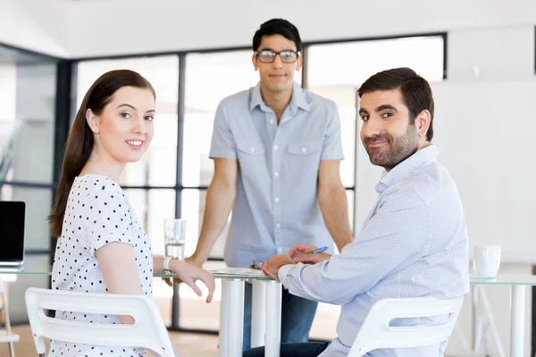 Groep van gelukkige jonge zakenmensen in een vergadering — Stockfoto