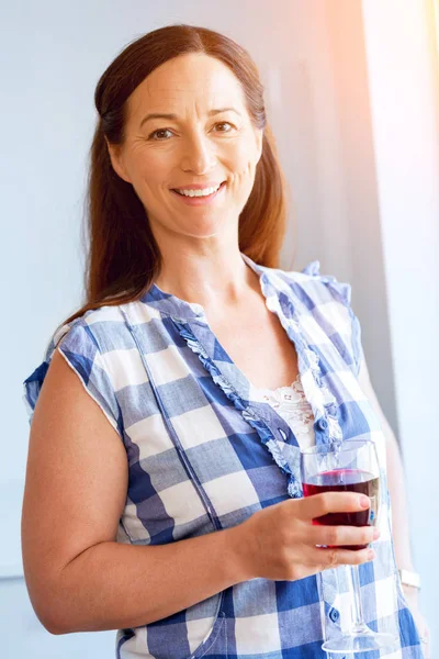 Donna con in mano un bicchiere di vino in casa — Foto Stock