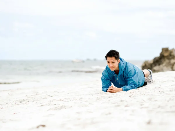 Jonge man doen oefening op het strand — Stockfoto