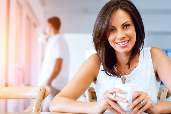 Happy young woman with cup of tea or coffee — Stock Photo, Image