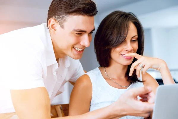 Feliz casal moderno trabalhando no laptop em casa — Fotografia de Stock