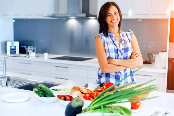 Mulher bonita de pé na cozinha e sorrindo — Fotografia de Stock