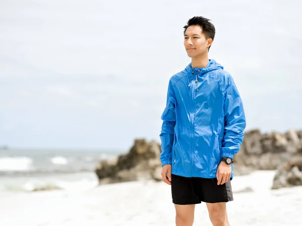 Jonge man staande op het strand — Stockfoto