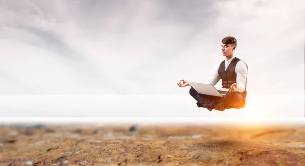 Businessman in lotus pose. Mixed media — Stock Photo, Image