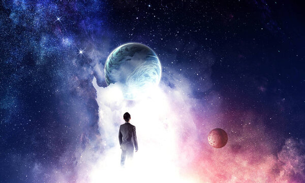 Back view of businessman on fantasy space background. Elements of this image are furnished by NASA