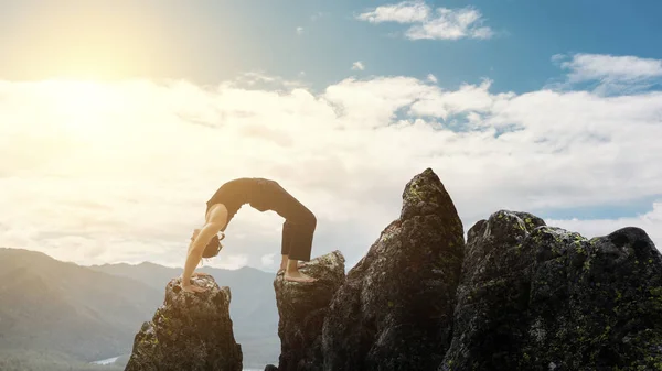 Человек делает сложные упражнения йоги стойку на голове. Удивительный пейзаж йоги в красивых горах. Опасные трюки. Трассировщик стоит на ладонях на краю обрыва. . — стоковое фото