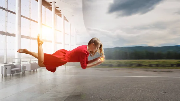 Vrouw vliegen in de lucht en mobiel gebruik. Mixed media — Stockfoto