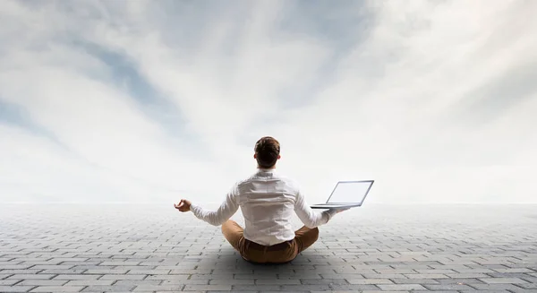 Businessman in lotus pose. Mixed media — Stock Photo, Image