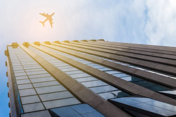 Airplane above business city — Stock Photo, Image