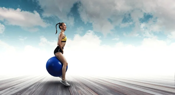 Спортивна жінка на фітнес-кулі. Змішані носії — стокове фото