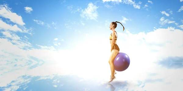 Sportieve vrouw op fitness bal. Mixed media — Stockfoto