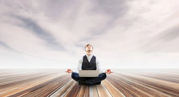 Businessman in lotus pose. Mixed media — Stock Photo, Image