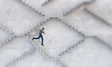 Siyahi işadamı kariyer gelişimini ve başarı kavramını gösteren taş basamakları tırmanıyor. Karışık ortam