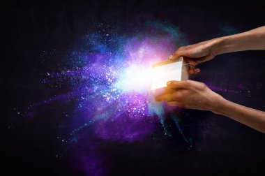 Adam eller küçük bir sihirli kağıt kutusu tutarak,