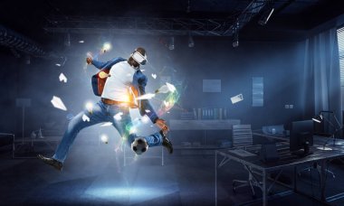 Siyah bir erkek futbol oynarken sanal gerçeklik kulaklığı. Karışık ortam