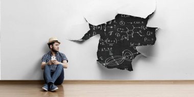 Yerde oturan genç adam, rahatlama konsepti. Karışık ortam