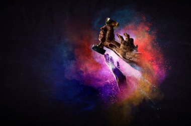 Renkli arka planda şampiyonluk kupasını tutan eller. Karışık ortam