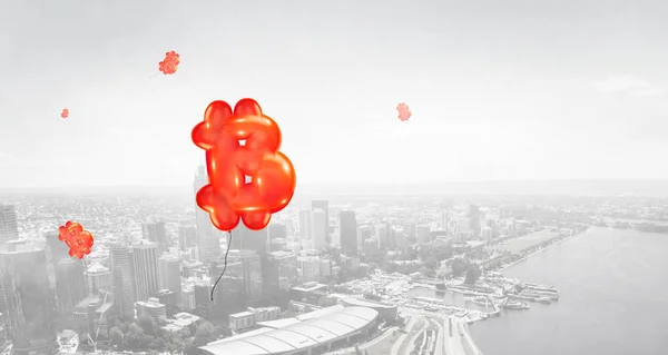 Tanda merah bitcoin terbang seperti balon di udara kota — Stok Foto