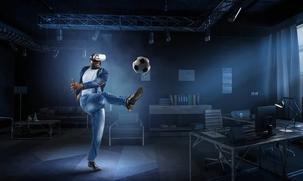 Sluchátka virtuální realita na černém muži hrající fotbal — Stock fotografie