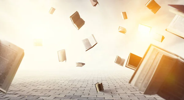 Offene Bücher fliegen auf hellem Himmel umher — Stockfoto
