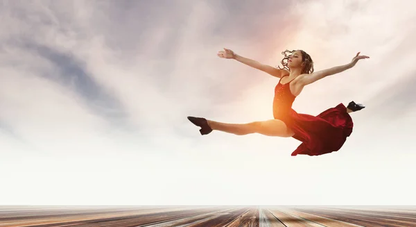 Young and beautiful female dancer in a red dress. Mixed media — Stock Photo, Image