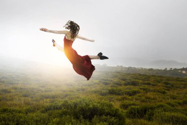 Kırmızı elbiseli genç ve güzel bir bayan dansçı. Karışık ortam