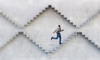 Siyahi işadamı kariyer gelişimini ve başarı kavramını gösteren taş basamakları tırmanıyor. Karışık ortam