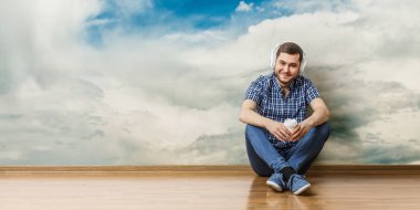 Yerde oturan genç adam, rahatlama konsepti. Karışık ortam