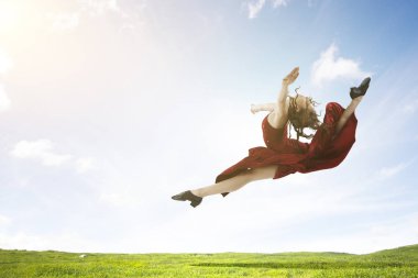 Kırmızı elbiseli genç ve güzel bir bayan dansçı. Karışık ortam