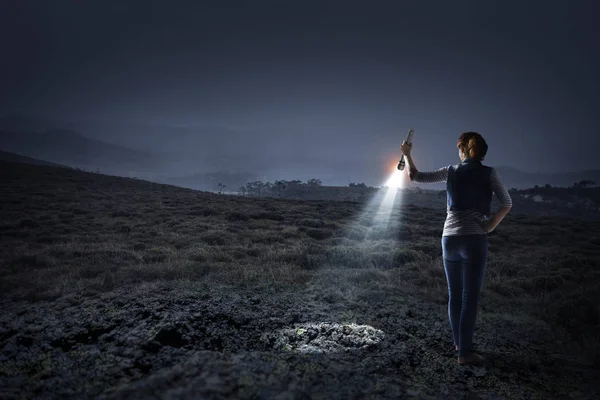 Jeune femme tenant une lampe de poche — Photo