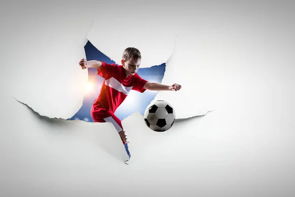 紙の破れた穴の効果とサッカーをプレイしている子供。混合メディア — ストック写真
