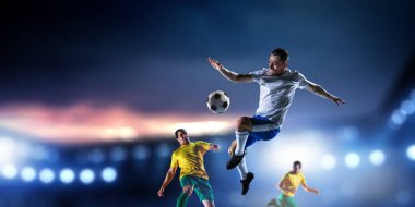 Stadyumdaki futbol oyuncuları iş başında. Karışık ortam
