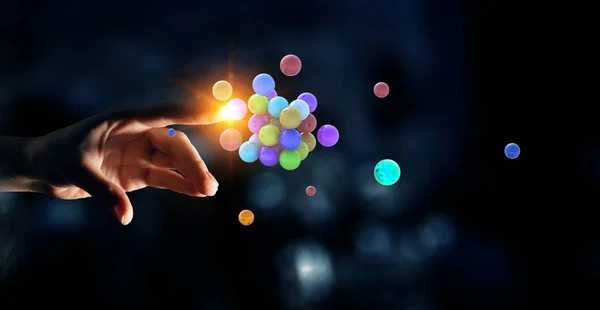 Woman hand and a bunch of colourful spheres levitating above. Mixed media — Stock Photo, Image